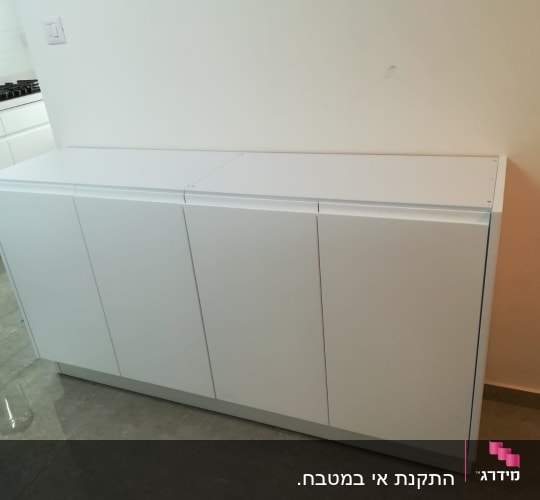 ארון לבן עם דלתות סגורות במטבח מודרני